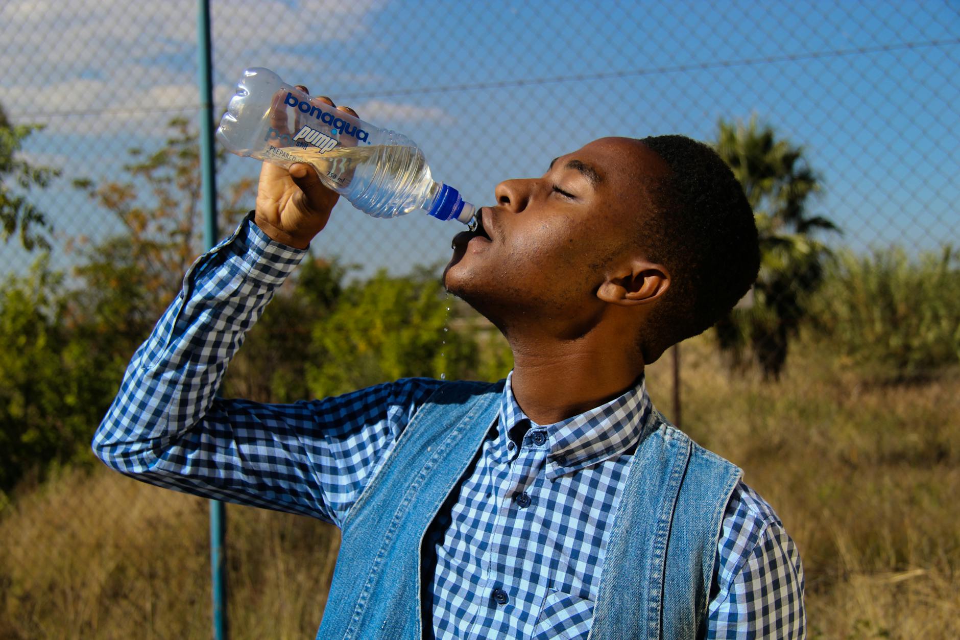 photography of a man drinking water