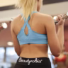 Two women lifting dumbbells in a gym, focusing on fitness and strength training.