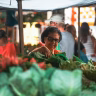 woman picking fresh green vegetables market stall Saúde e Bem-estar