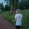 senior woman walking in sunlit park Saúde e Bem-estar