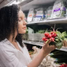 woman selecting vegetables at market Saúde e Bem-estar