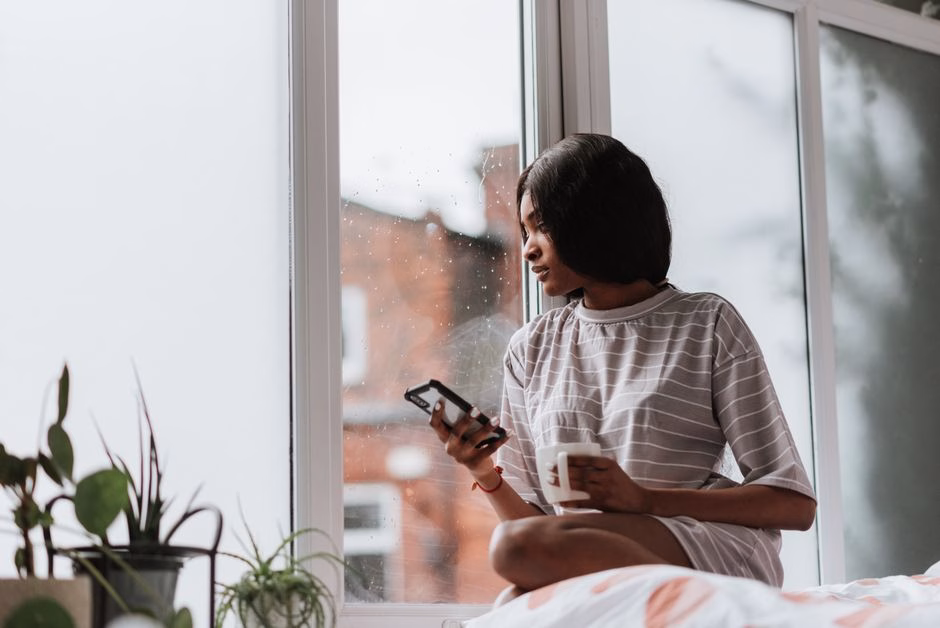 woman sitting rainy window saude