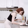 woman clutching chest kitchen Saúde e Bem-estar