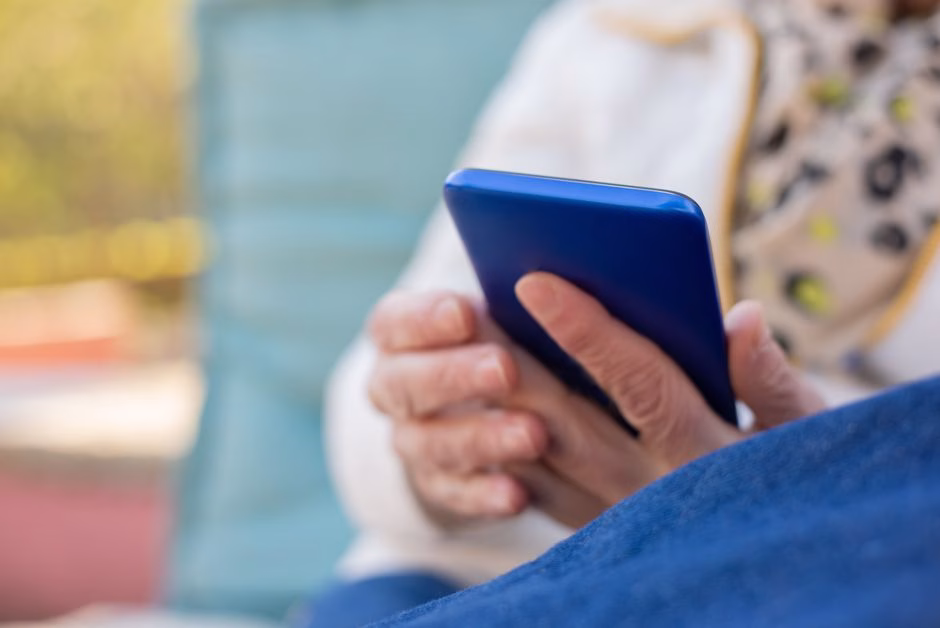 Senior woman hands holding smartphone showing heart rate graph Saúde e Bem-estar