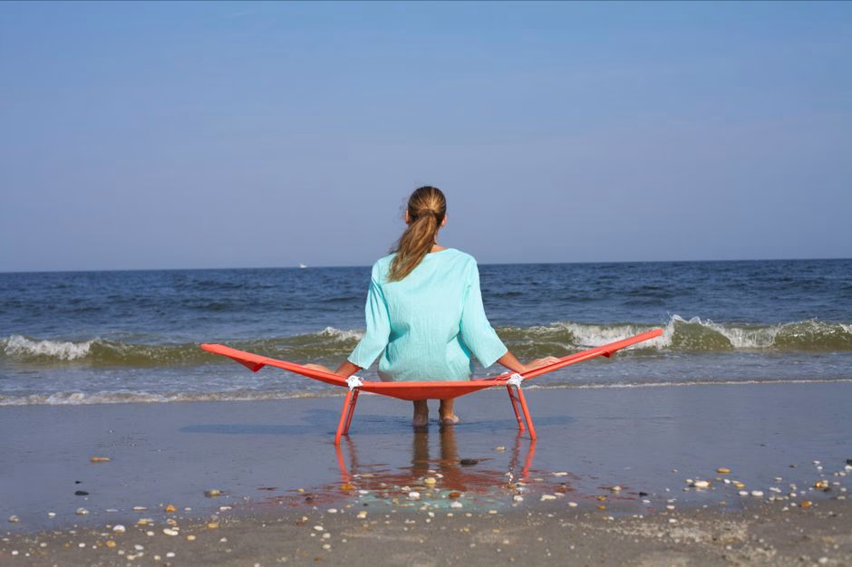Woman sitting beach chair ocean horizon Saúde e Bem-estar